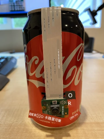 相機懸掛在飲料罐上方